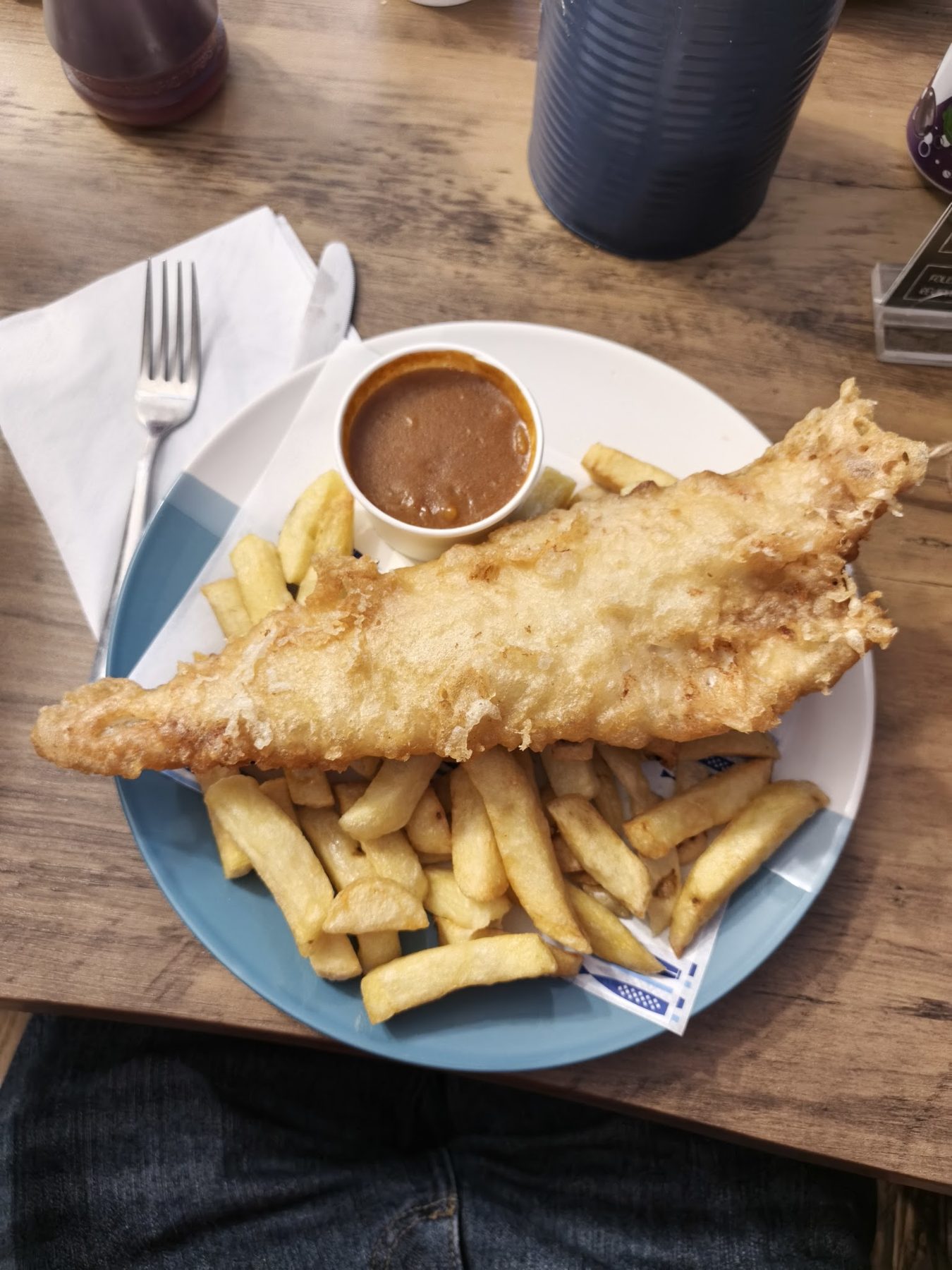 Battered fish and chips with a pot of gravy