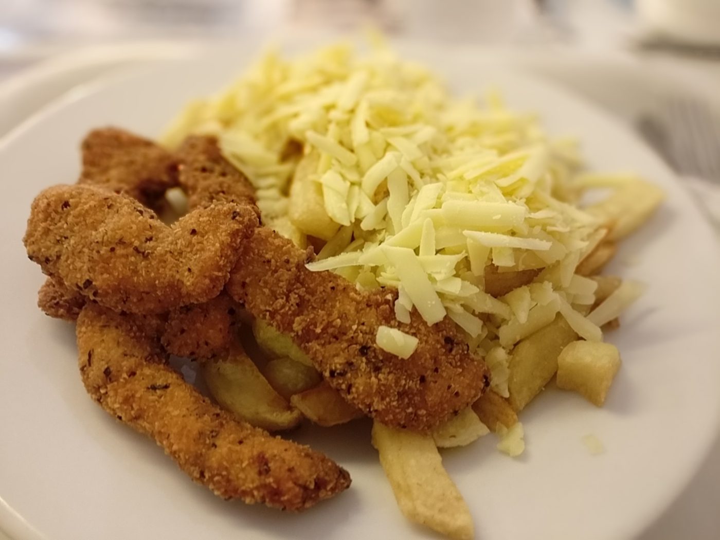 Chicken strips and chips with grated cheese